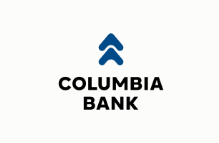Columbia Bank logo featuring two blue arrow shapes pointing upward above the bold black text “COLUMBIA BANK” on a white background.