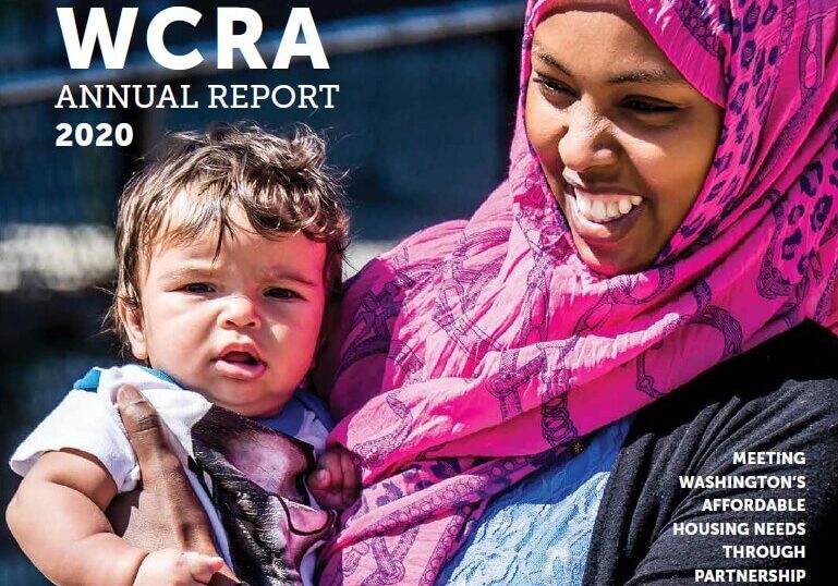 A woman in a pink headscarf smiles while holding a baby outside. Text reads “WCRA Annual Report 2020” and “Meeting Washington’s Affordable Housing Needs Through Partnership.” Highlighting the impact showcased in Washington Community Reinvestment Association annual reports, the image captures the spirit of community and collaboration.