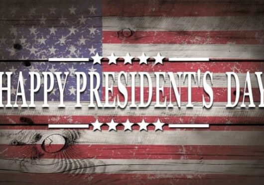 Text “Happy Presidents’ Day” in white over a U.S. flag painted on wooden planks, with white stars above and below the text, celebrating Presidents’ Day with a classic patriotic touch.